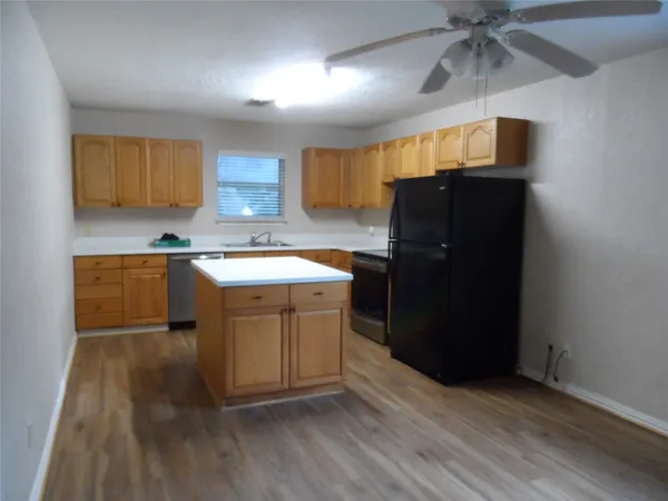 a kitchen with a sink a refrigerator and cabinets