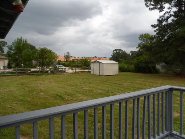 a view of a wooden deck and garden with trees