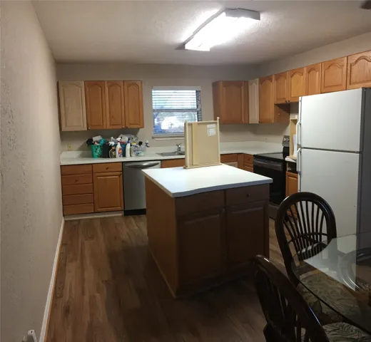 a kitchen with a sink a stove a refrigerator and a cabinets