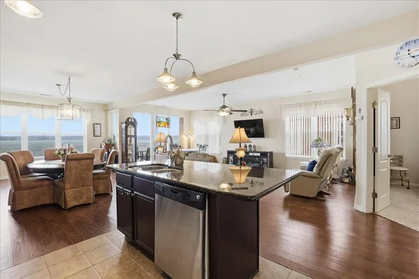 a living room with furniture kitchen view and a chandelier