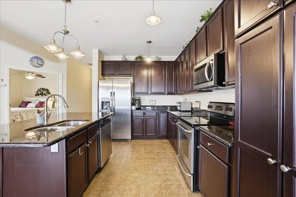 a kitchen with stainless steel appliances granite countertop a sink a stove and refrigerator