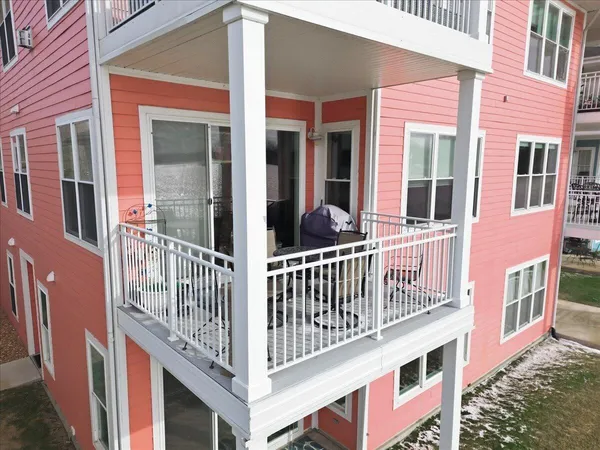 a view of a brick house with large windows and a small yard