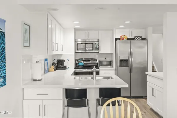 a kitchen with white cabinets and stainless steel appliances