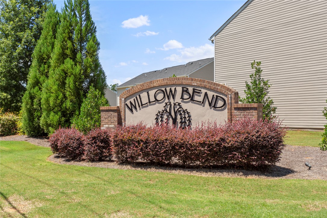 137 Nicklaus Drive Anderson, SC 29621 - Photo 36 of 37 A welcoming community entrance, featuring a brick sign framed by meticulously maintained landscaping and vibrant foliage.