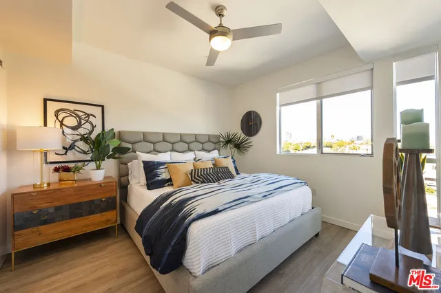 a bedroom with a large bed and a potted plant
