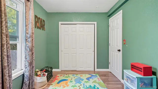 a view of kids room with toys and a window