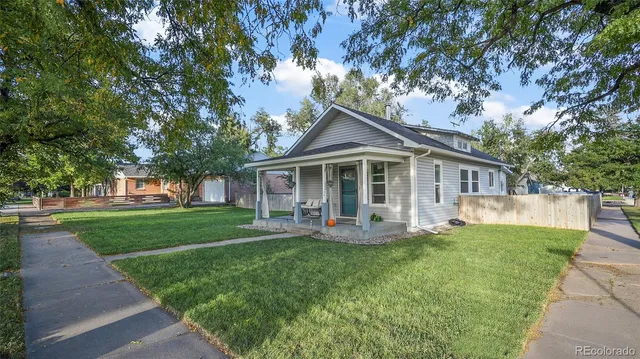 a front view of a house with a yard and trees
