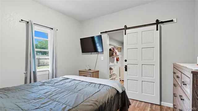 a bedroom with a bed and a flat tv screen on the dresser