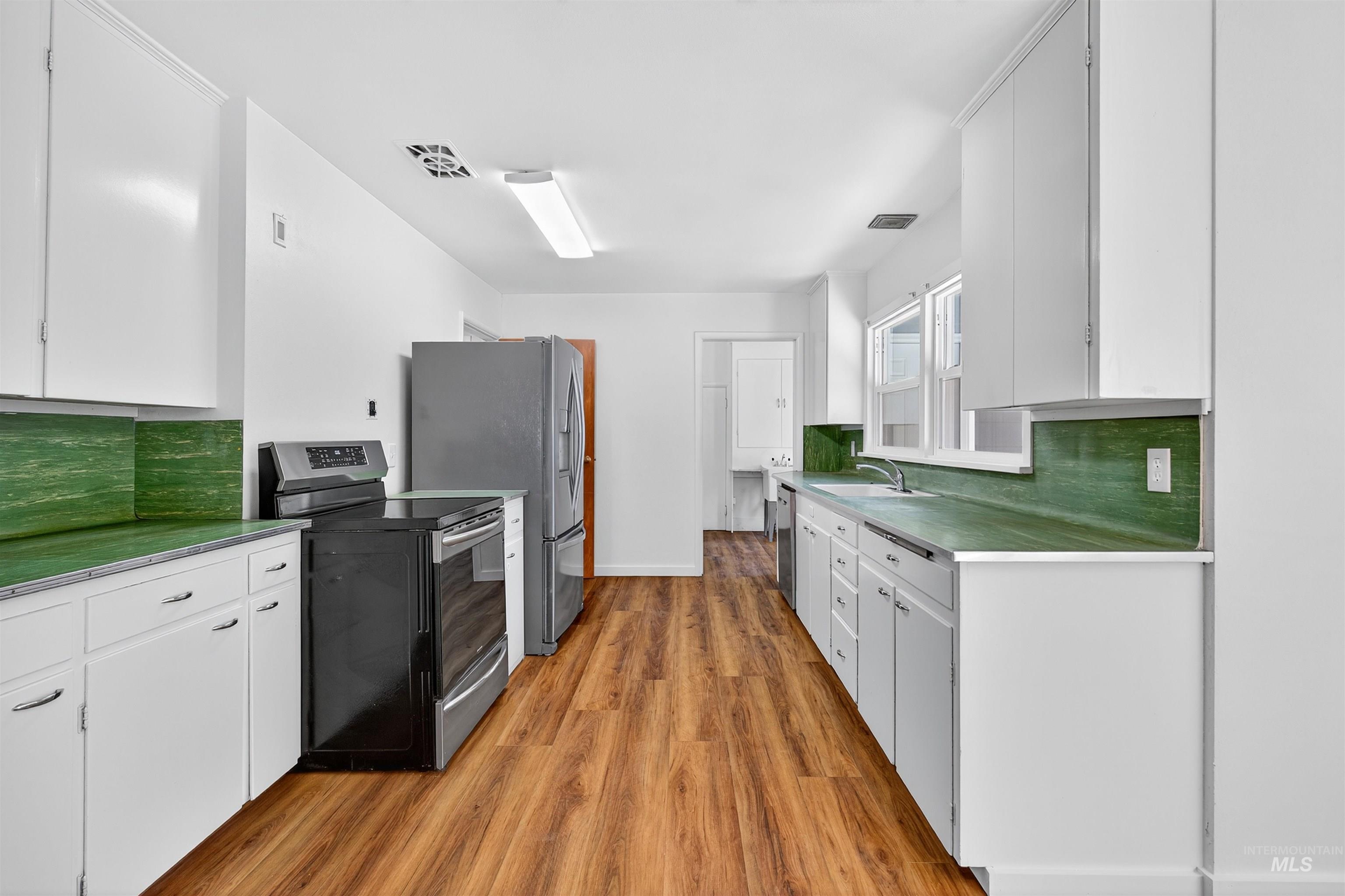 164 State Street Juliaetta, ID 83535 - Photo 15 of 37 Kitchen featuring backsplash, stainless steel appliances, and white cabinets