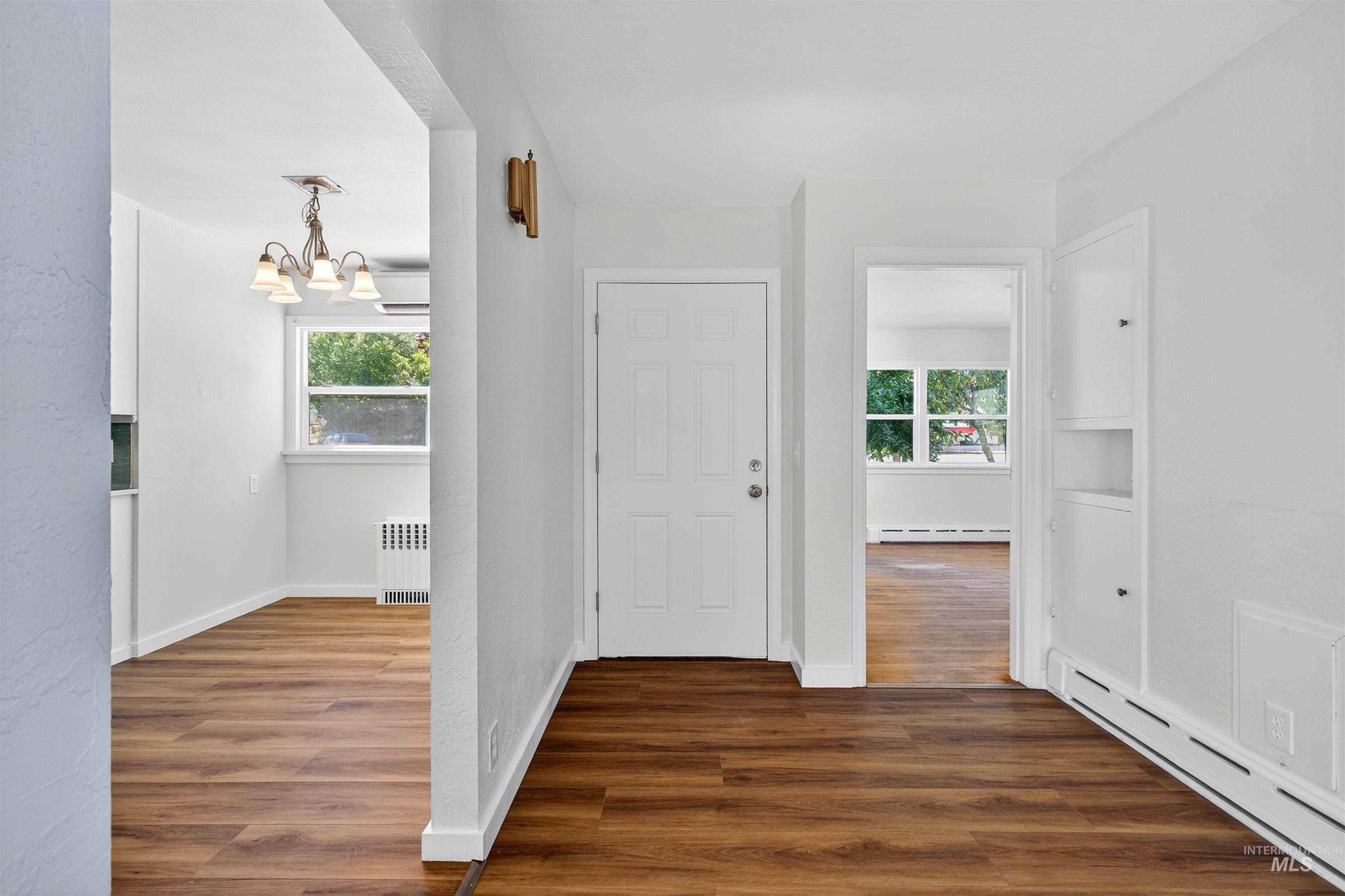 164 State Street Juliaetta, ID 83535 - Photo 7 of 37 Foyer entrance featuring a baseboard radiator, dark wood-style floors, radiator, and a chandelier