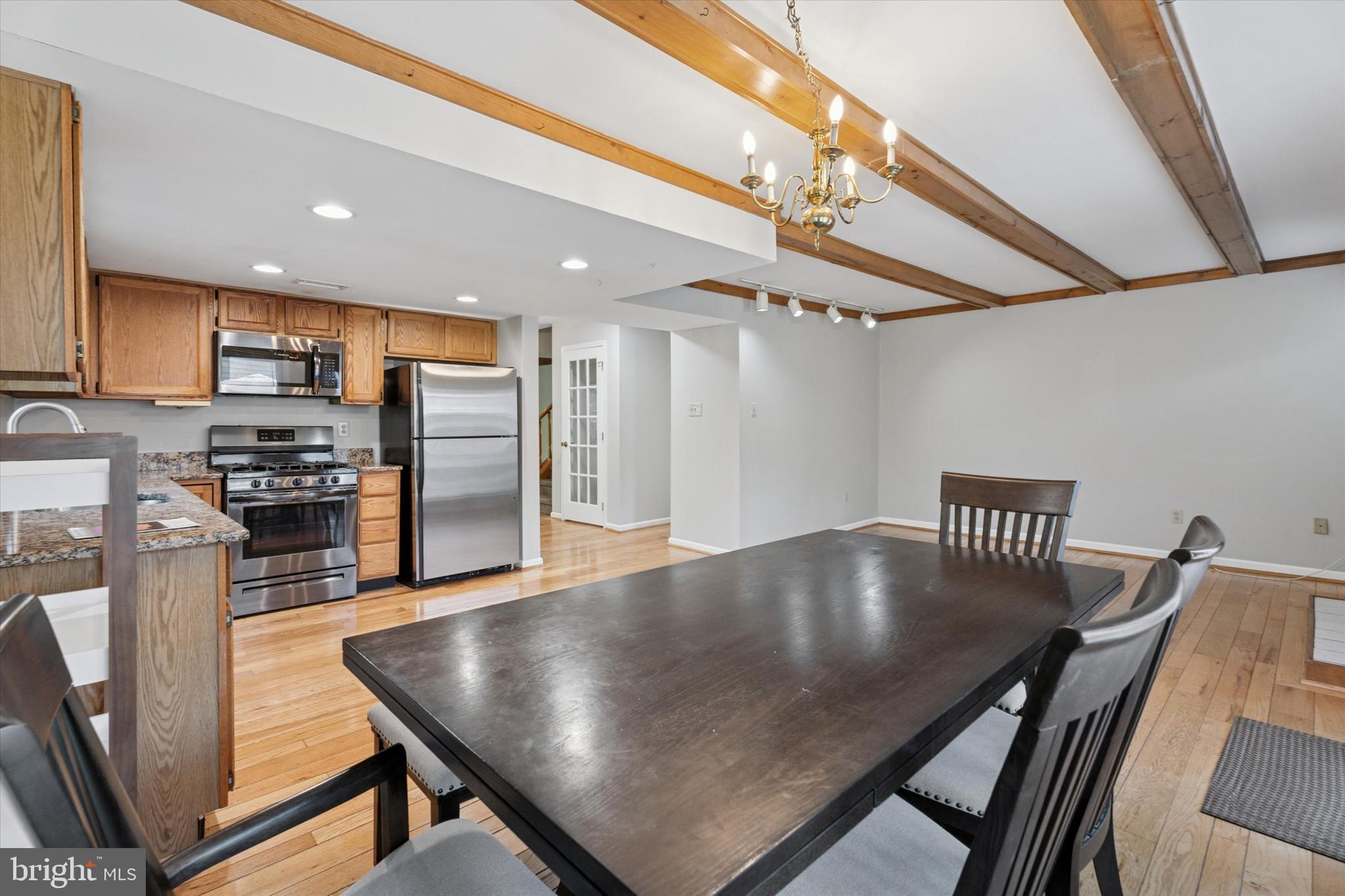 82 Bunker Hill Court, Unit 82 Wayne, PA 19087 - Photo 5 of 23 a kitchen with stainless steel appliances granite countertop a sink a stove a refrigerator a table and chairs