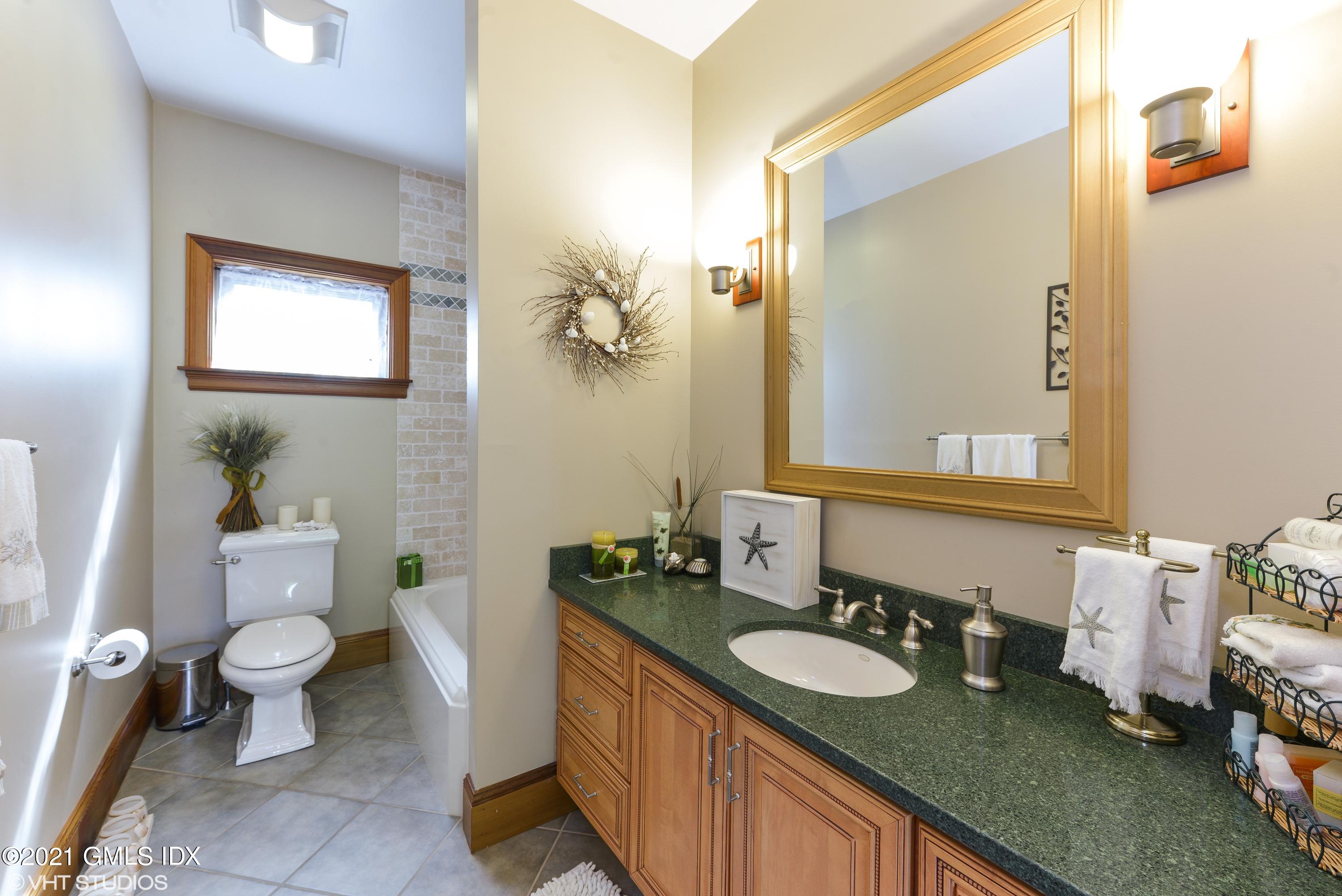 78 Long Meadow Road Riverside, CT 06878 - Photo 10 of 18 a bathroom with a granite countertop toilet a sink and a mirror