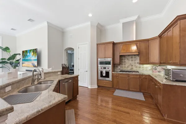 a kitchen with stainless steel appliances granite countertop a sink stove and refrigerator