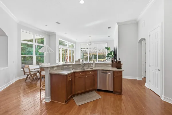a kitchen with granite countertop kitchen island stainless steel appliances a sink a stove a table and chairs
