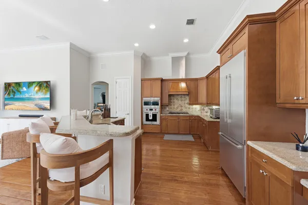 a living room with furniture kitchen view and a large window