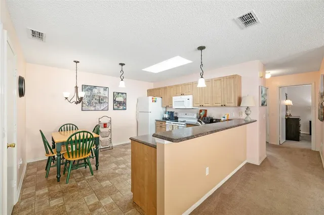 a kitchen with stainless steel appliances kitchen island granite countertop a sink and a refrigerator