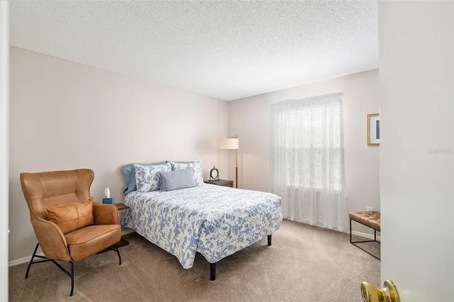 a bedroom with a bed chair and a window