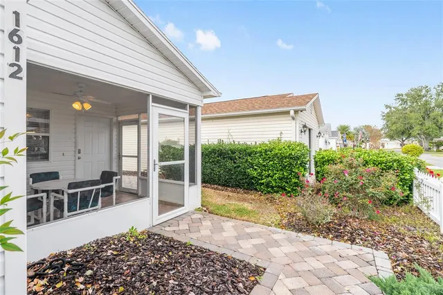 a view of a porch with chairs and potted plants