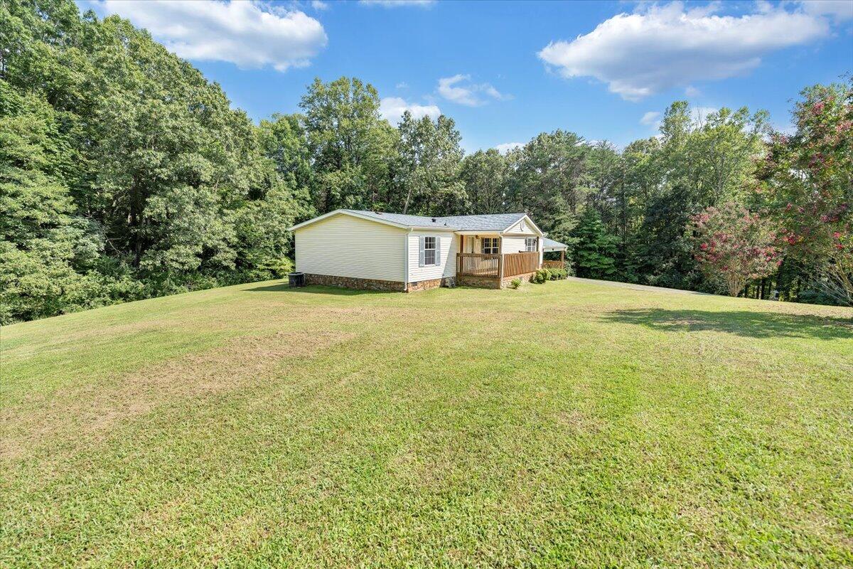 1102 Thomasson Mill Road Goodview, VA 24095 - Photo 42 of 45 a view of a large tree with lawn chairs and a table
