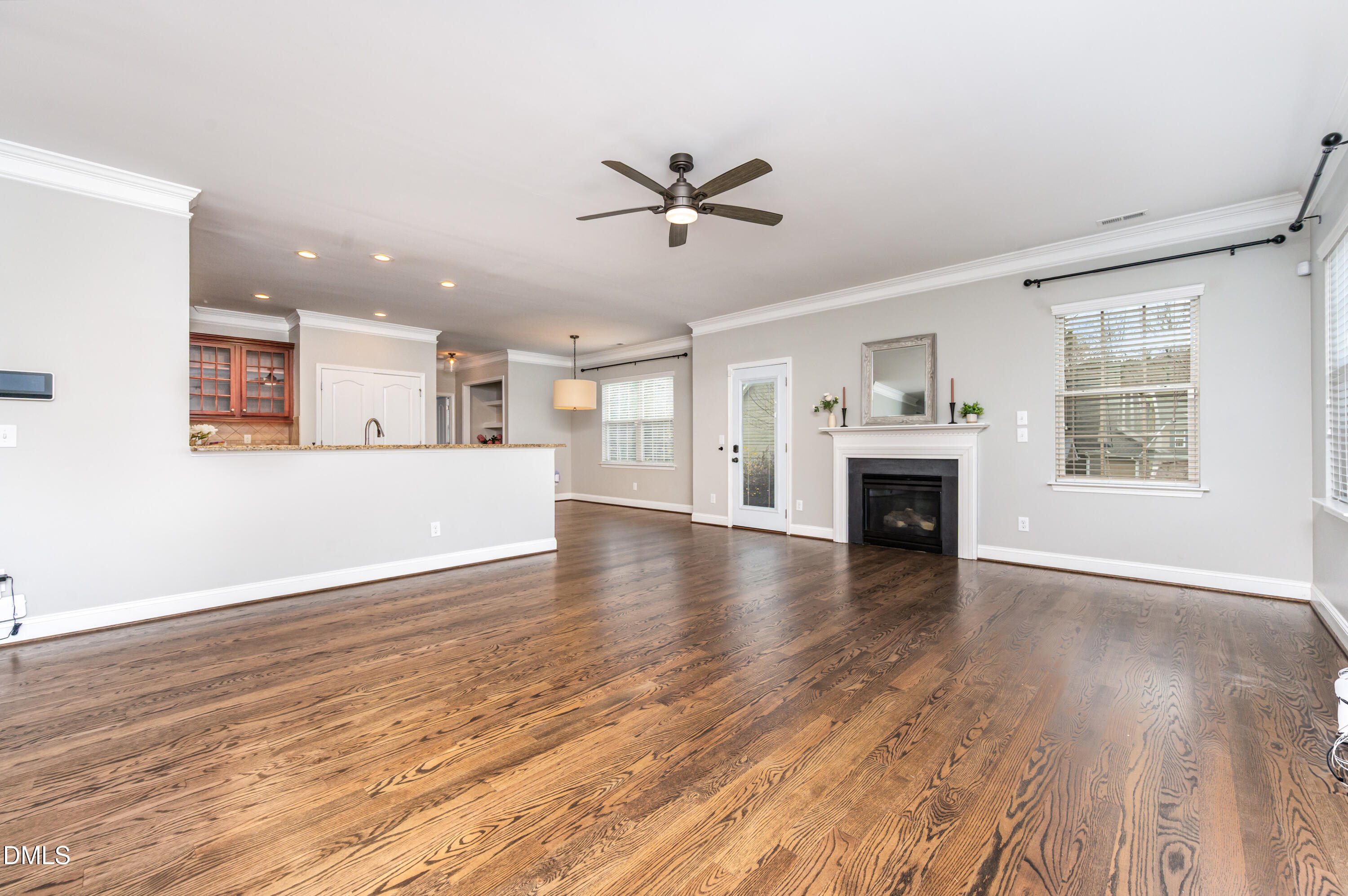 1956 Lazio Lane Apex, NC 27502 - Photo 11 of 47 an empty room with wooden floor a ceiling fan and windows