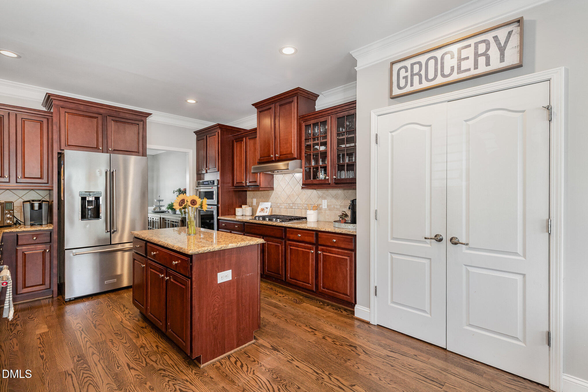 1956 Lazio Lane Apex, NC 27502 - Photo 13 of 47 a kitchen with stainless steel appliances granite countertop a refrigerator a stove and a sink with wooden cabinets