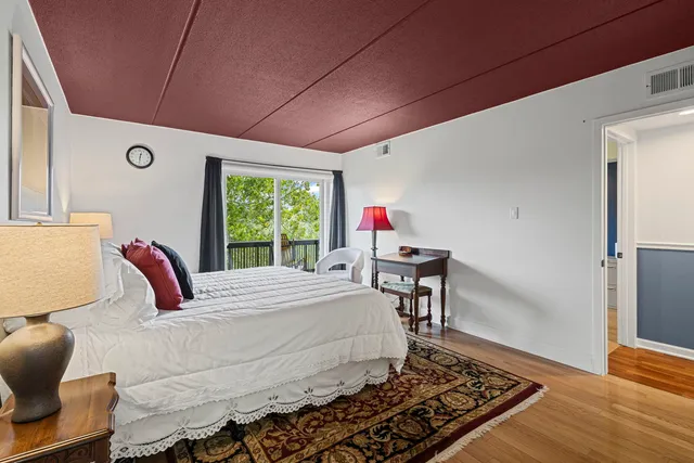 a bedroom with a bed wooden floor and window