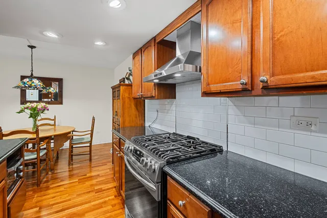 a kitchen with stainless steel appliances granite countertop a stove a sink and a microwave