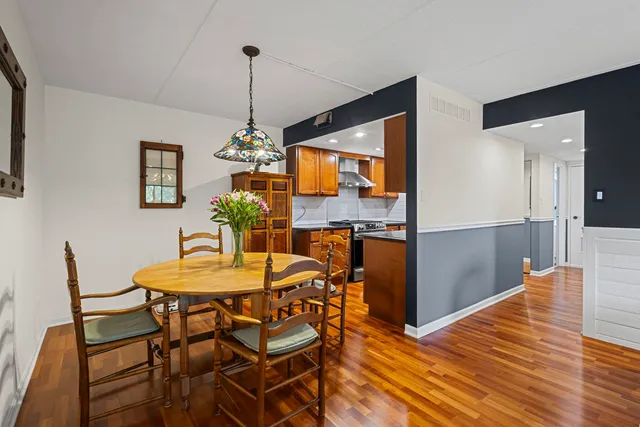 a dining room filled chandelier and wooden floor
