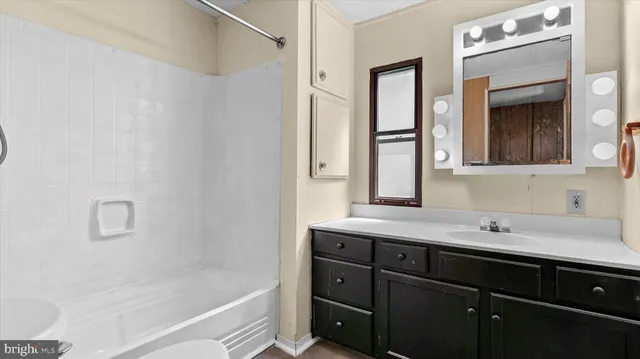 a bathroom with a tub sink and mirror