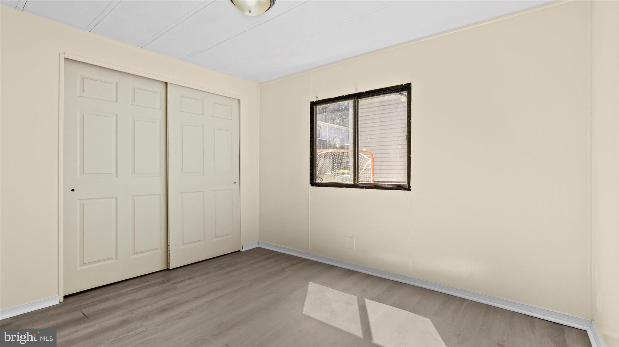 4518 Rolo Court Mechanicsburg, PA 17055 - Photo 14 of 16 a view of an empty room with wooden floor and a window