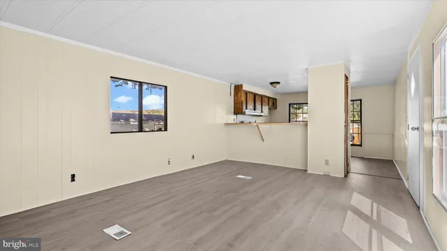 a view of a big room with wooden floor and windows