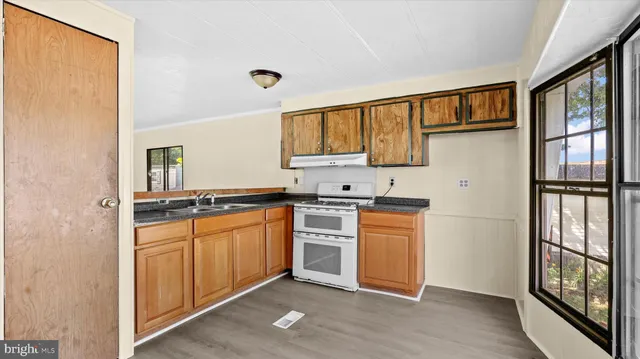 a kitchen with stainless steel appliances granite countertop a refrigerator and a stove top oven