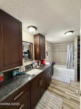 a spacious bathroom with a granite countertop sink and a mirror