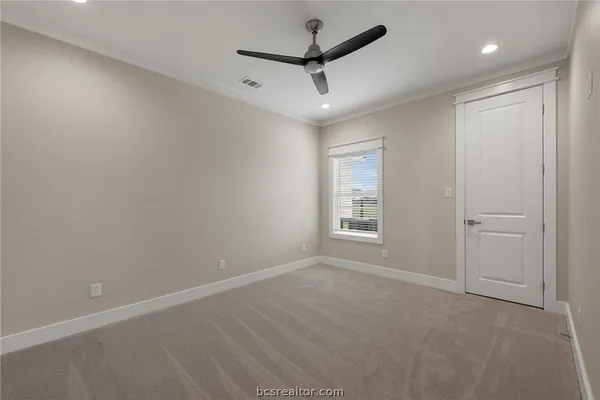 an empty room with a ceiling fan and windows