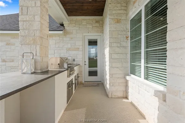 a bathroom with a granite countertop sink and washing machine