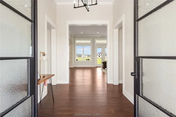 a view of a hallway with wooden floor and furniture