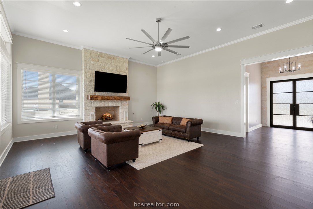7844 Mathis Crk Drive Bryan, TX 77808 - Photo 10 of 48 a living room with furniture a flat screen tv and a fireplace