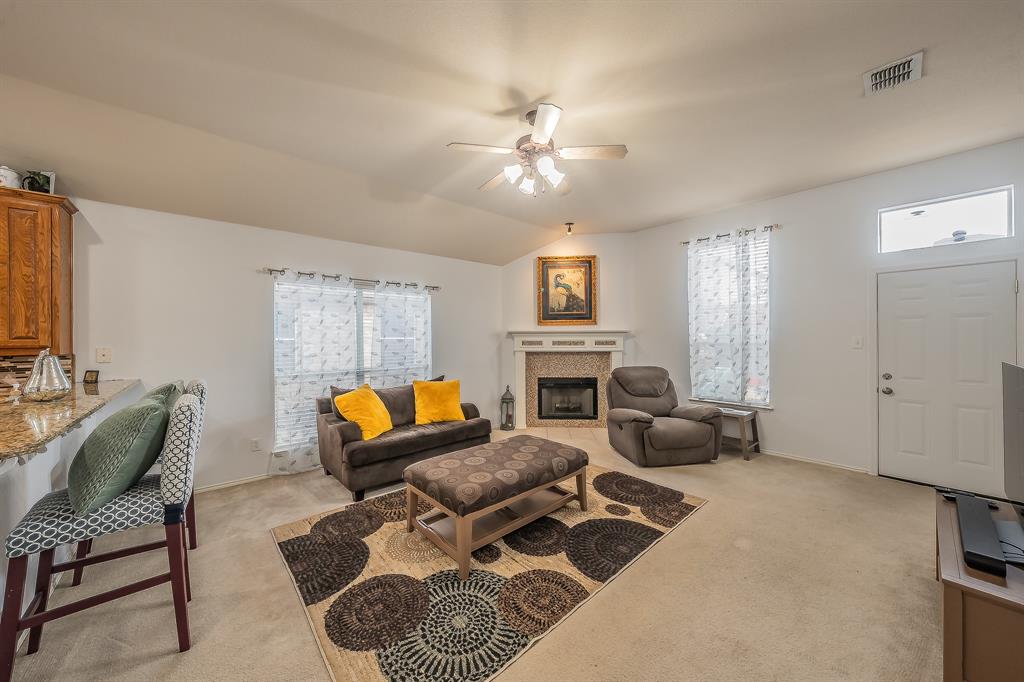 8312 Trinity Vista Trail Hurst, TX 76053 - Photo 21 of 37 Living area with light carpet, a ceiling fan, lofted ceiling, and a tile fireplace