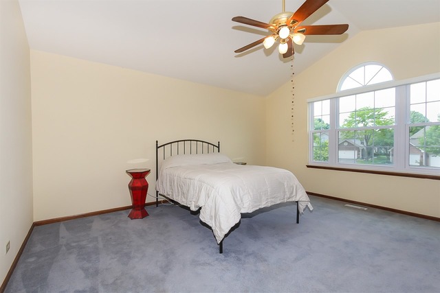 1230 Coldspring Road, Unit 1230 Elgin, IL 60120 - Photo 14 of 21 a bed room with a bed and a chandelier