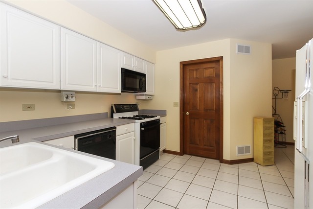 1230 Coldspring Road, Unit 1230 Elgin, IL 60120 - Photo 7 of 21 a kitchen with a sink a stove and a refrigerator