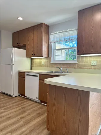 a kitchen with stainless steel appliances a refrigerator sink and white cabinets