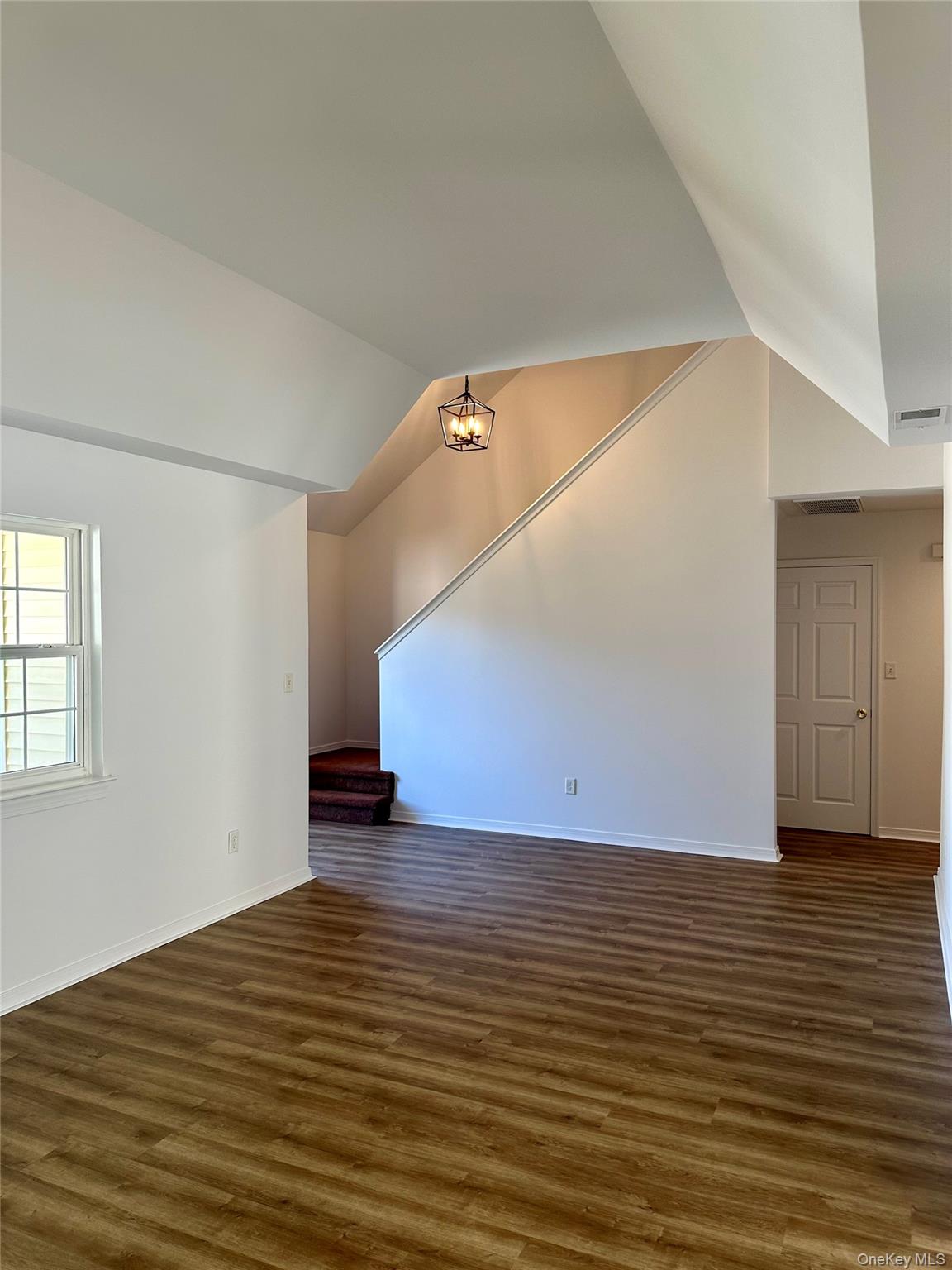 1403 Pebble Beach Path Riverhead, NY 11901 - Photo 8 of 35 Primary living room leading to upstairs, attached laundry room with access to garage, and half bath.
