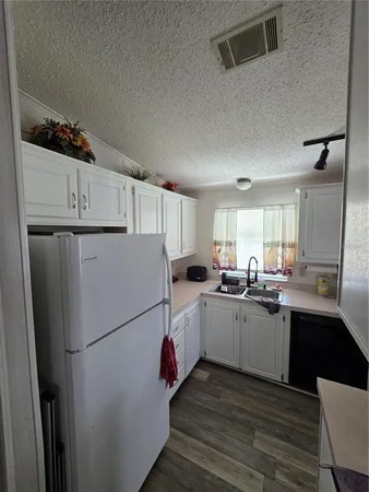 a kitchen with refrigerator and cabinets