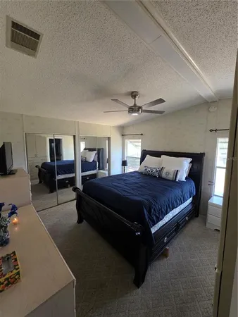 a spacious bedroom with a bed and wooden floor