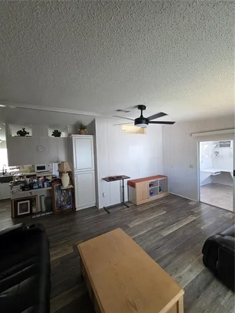 a living room with stainless steel appliances kitchen island a stove and a refrigerator