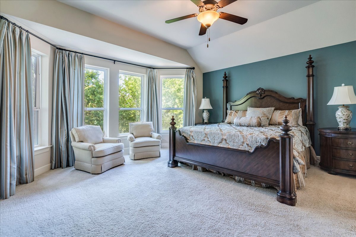 12909 Medina River Way Austin, TX 78732 - Photo 21 of 36 Plentiful natural light streams through large bay windows into this comfortable primary bedroom suite.