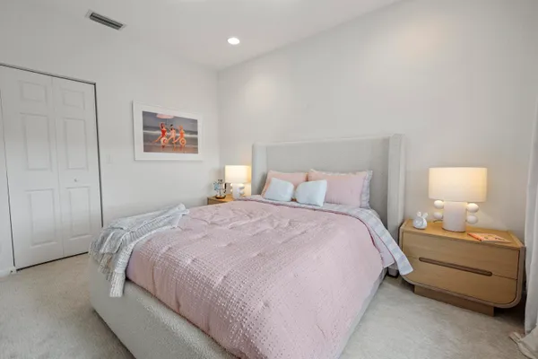 a bedroom with a bed and a painting on the wall