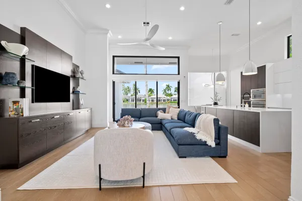 a living room with furniture a flat screen tv and a large window