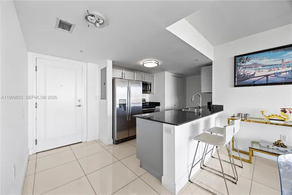 a kitchen with stainless steel appliances kitchen island granite countertop a refrigerator and a stove