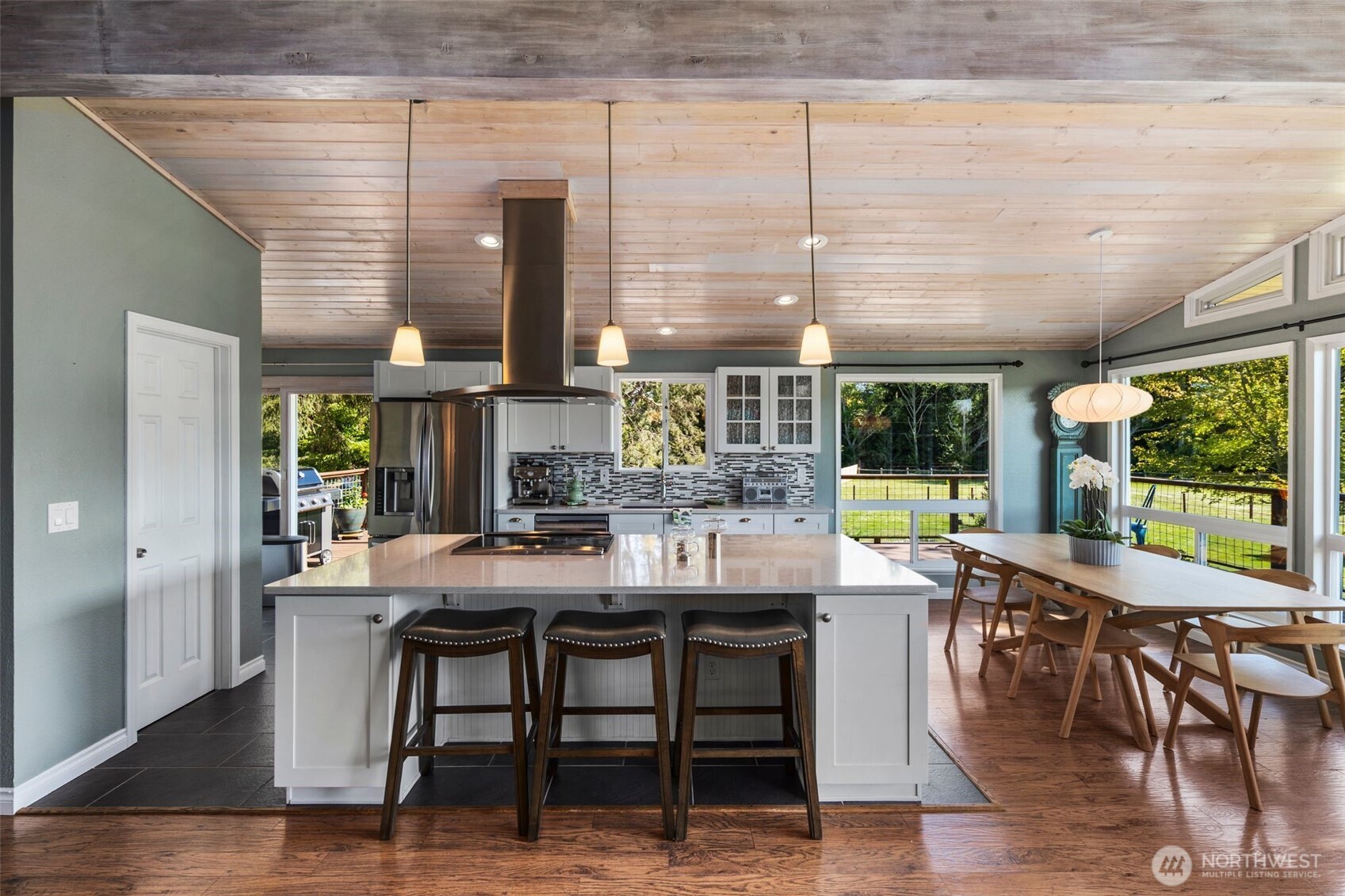 734 Shore Road Port Angeles, WA 98362 - Photo 12 of 40 a dining hall with stainless steel appliances granite countertop a stove a refrigerator a dining table and chairs with wooden floor